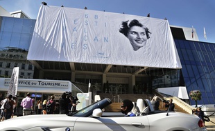 La bâche en train d'être hissée, sur le fronton du Palais des festivals de Cannes, le 11 mai 2015.
