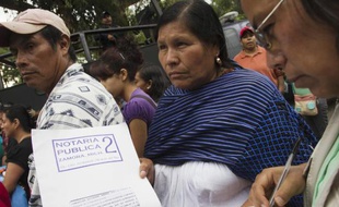 Une Mexicaine exhibe le contrat que les parents signaient en confiant la garde de leurs enfants au foyer "La Gran Familia"(la grande famille) où la police a fait un raid et libéré 596 personnes dont 458 enfants à Zamora, au Mexique le 16 juillet 2014