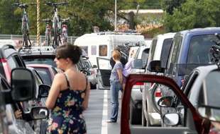 Des vacanciers français coincés dans les embouteillages patientent près de leurs véhicules, à Royan, le 22 août 2010.