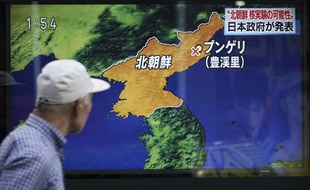 Un passant devant une télévision et une carte montrant le lieu de l'explosion d'un essai nucléaire nord-coréen, le 3 septembre 2017 à Tokyo au Japon