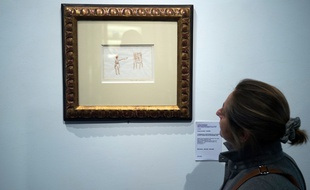 Une femme passe devant une aquarelle originale du