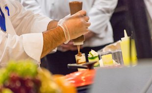 Préparation d'un repas par des chefs cuisiniers (illustration).