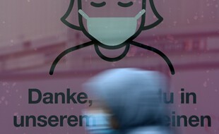 Une affiche prônant le port du masque sur la vitrine d'un magasin, le 22 octobre 2020 à Munich, en Allemagne.
