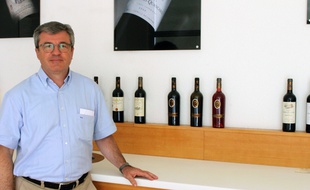 Roland Quancart compare vins et étiquettes dans une salle de dégustation.