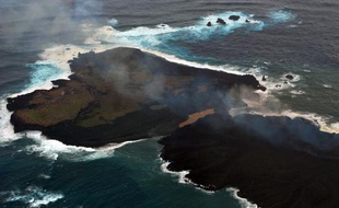 Au Japon, une petite île née il y a un mois d'une forte activité volcanique (sur la droite) est en train de se fondre avec une île plus ancienne. Photo prise par les garde-côtes japonais, le 26 décembre 2013.