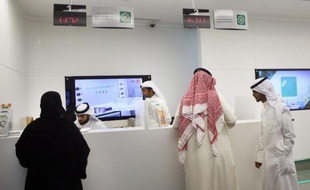 Des clients koweïtiens au comptoir d'une banque dans un centre commercial à Koweit City, le 19 novembre 2014