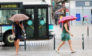 Deux femmes marchent sous la pluie à Rennes, en été (illustration).