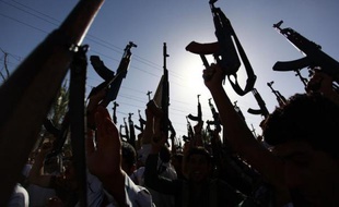 Des Irakiens chiites brandissent leurs armes pour montrer leur volonté de rejoindre les combats anti-jihadistes, le 17 juin 2014 à Najaf au sud de l'Irak