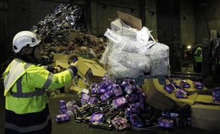 Un homme manipule une pile de jouets contrefaits lors d'une opération de destruction à Créteil le 17 décembre 2014