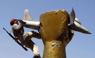 Un rebelle libyen s'en prend à la statue de Mouammar Kadhafi, le 24 août 2011 à Bab al-Aziziya (Tripoli).