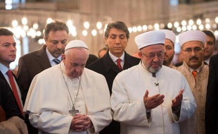 Le pape François (g) se recueille dans la Mosquée bleue d'Istanbul aux côtés du grand mufti Rahmi Yaran, le 29 novembre 2014