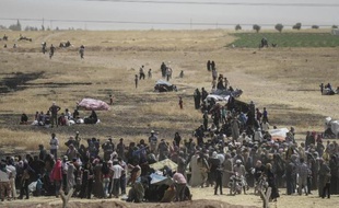 Des réfugiés syriens attendent entre les frontières syrienne et turque dans l'attente de passer en Turquie, à Akcakale, le 9 juin 2015