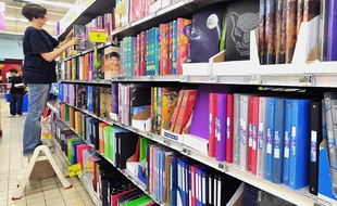 Une vendeuse range un rayon de fournitures pour la rentrée scolaire, le 16 août 2010, dans une grande surface à Lille.