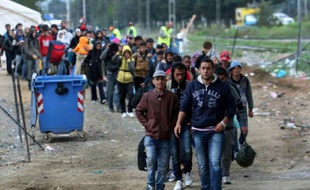 Des migrants traversent la frontière entre la Grèce et la Macédoine près du village de Idomeni, le 14 octobre 2015