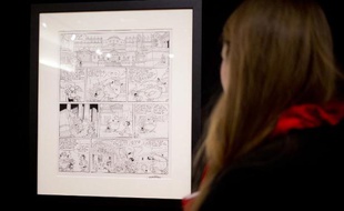 Une personne regarde une planche originale de l'album d'Astérix "Les Lauriers de César" vendue par Christie's, le 14 mars 2015 à Paris