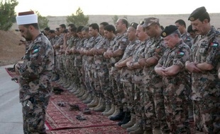 Une photo distribuée par le Palais royal du roi Abdallah II qui prie avec des soldats dans un endroit non défini en Jordanie, le 20 juin 2016