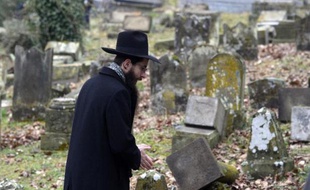 Un membre de la communauté juive observe les tombes profanées du cimetière Sarre-Union, dans le Bas-Rhin, le 17 février 2015