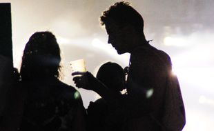 Un homme et une femme partagent un verre de bière devant une scène du festival des Vieilles Charrues, en 2015.