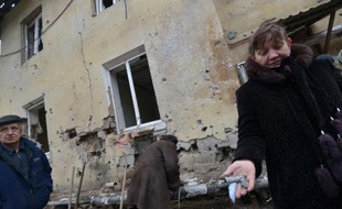 Une femme montre des éclats d'obus le 8 février 2015 à Donetsk, après un bombardement du quartier Leninski