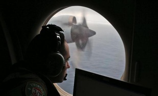 Un soldat dans un avion de l'armée australienne scrute l'océan Indien à la recherche d'éventuels débris du vol MH370 de la Malaysia Airlines, le 22 mars 2014