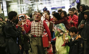 Des membres de l'association Nez rouges viennent divretir les migrants dans la gare de Vienne, le 15 octobre 2015