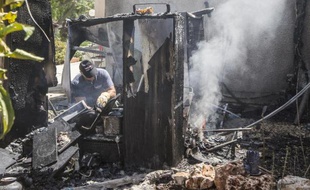 Un expert israélien éteint l'incendie provoqué par la chute d'une roquette palestinienne sur Kfar Aza, le 14 juillet 2014