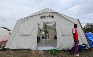 Un homme devant une tente Unicef dédiée aux patients infectés avec le virus Ebola à Monrovia le 12 août 2014