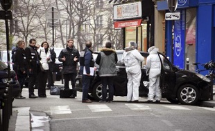 Policiers et enquêteurs examinent le véhicule utilisé par les assaillants qui ont attaqué les locaux du journal satirique Charlie Hebdo faisant au moins 12 morts, le 7 janvier 2014 à Paris