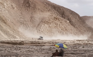 Spectators sit in a canyon to watching stage four of the Dakar Rally between Arequipa and Moquegua, Peru, Thursday, Jan. 10, 2019.