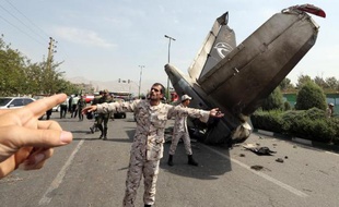 Des gardiens de la révolution et de membres des forces de sécurité iraniennes sur le site du crash près de l'aéeoport Mehrabad de Téhéran, le 10 août 2014