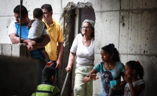 Des gens attendent à l'intérieur de la Tour David, un immeuble squatté de Caracas, le 22 juillet 2014