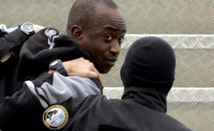 Youssouf Fofana escorté par deux policiers le 4 mars 2005 à l'aéroport d'Abijan