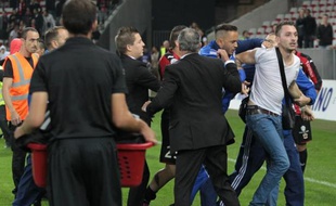 Un supporter niçois (à droite) est expulsé après être entré sur le terrain à la fin du match Nice-Bastia à Nice le 18 octobre 2014