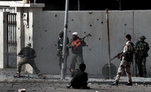Un homme joue de la guitare au milieu des forces du nouveau régime libyen qui affrontent les combattant pro-Kadhafi, le 10 octobre 2011. Cette photo a obtenu le prix Bayeux-Calvados 2012.
