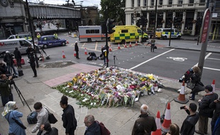 Londres (Royaume-Uni), le 06 Juin 2017. Des passants déposent des fleurs sur le London Bridge en hommage aux victimes de l'attentat de Londres.