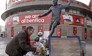 Un supporter de benfica dépose des fleurs devant la statut d'Eusebio au sta de la Luz, le 6 janvier 2014, à Lisbonne.