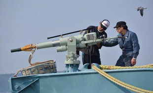 L'équipage d'un baleinier vérifie son harpon avant son départ en mer du port d'Ayukawa, à Ishinomaki, au Japon, le 26 avril 2014