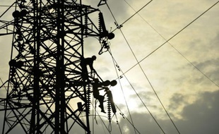 Des électricien indiens travaillent sur un pylone à New-Delhi, le 28 février 2015