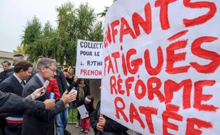 Le ministre de l'Education Vincent Peillon (g) parle le 30 septembre 2013 à Wittenheim avec des personnes manifestant contre la réforme des rythmes scolaires