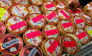 Un producteur de lait colle des stickers de protestations sur des fromages industriels, à St-Herblain, près de Nantes, le 3 août 2010.