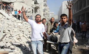 Des Syriens évacuent un blessé après un raid aérien sur la ville d'Alep, le 26 août 2013.