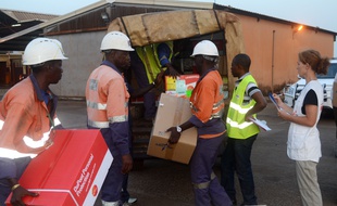 Des travailleurs guinéens chargent du matériel pour l'ONG Médecins sans frontières à l'aéroport de Conakry, le 29 mars 2014.