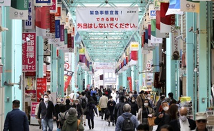 «C'est l'état d'urgence! Dans la mesure du possible, évitez de sortir», rappelle une bannière au-dessus d'une rue commerçante du quartier de Kichijoji à Tokyo, le 23 avril 2020.