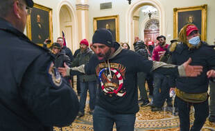 Trump supporters gesture to U.S. Capitol Police in the hallway outside of the Senate chamber at the Capitol in Washington, Wednesday, Jan. 6, 2021. (AP Photo/Manuel Balce Ceneta)/DCMC310/21006779971682//2101062244