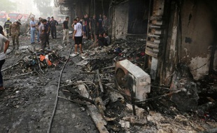 Bagdad (Irak), le 3 juillet. Des Irakiens inspectent les décombres après un attentat qui a fait au moins 213 morts le 2 juillet sur un marché de Bagdad.