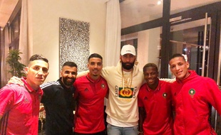 La Fouine entouré de joueurs de l'équipe du Maroc.