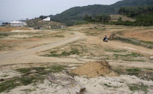 Au milieu des palmiers abattus, des pelleteuses modèlent un terrain de golf en bord de mer sur l'île tropicale chinoise de Hainan (sud), où les autorités ont réduit au silence un militant écologiste luttant pour protéger les forêts.