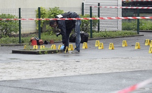Un enquêteur de la police recueille les indices après une fusillade au pied de l'immeuble de la cité Emile-Cordon, le 30 avril 2015.