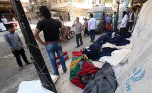 Les corps de victimes présumés de raids aux barils d'explosifs du régime syrien sont entreposés sur un trottoir d'Alep, dans le nord du pays, le 30 mai 2015