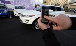 Un employé de Valeo utilise un logiciel sur son téléphone portable pour diriger le véhicule sans chauffeur à se garer tout seul, lors d'une démonstration dans le cadre d'un salon à Las Vegas, le 8 janvier 2014